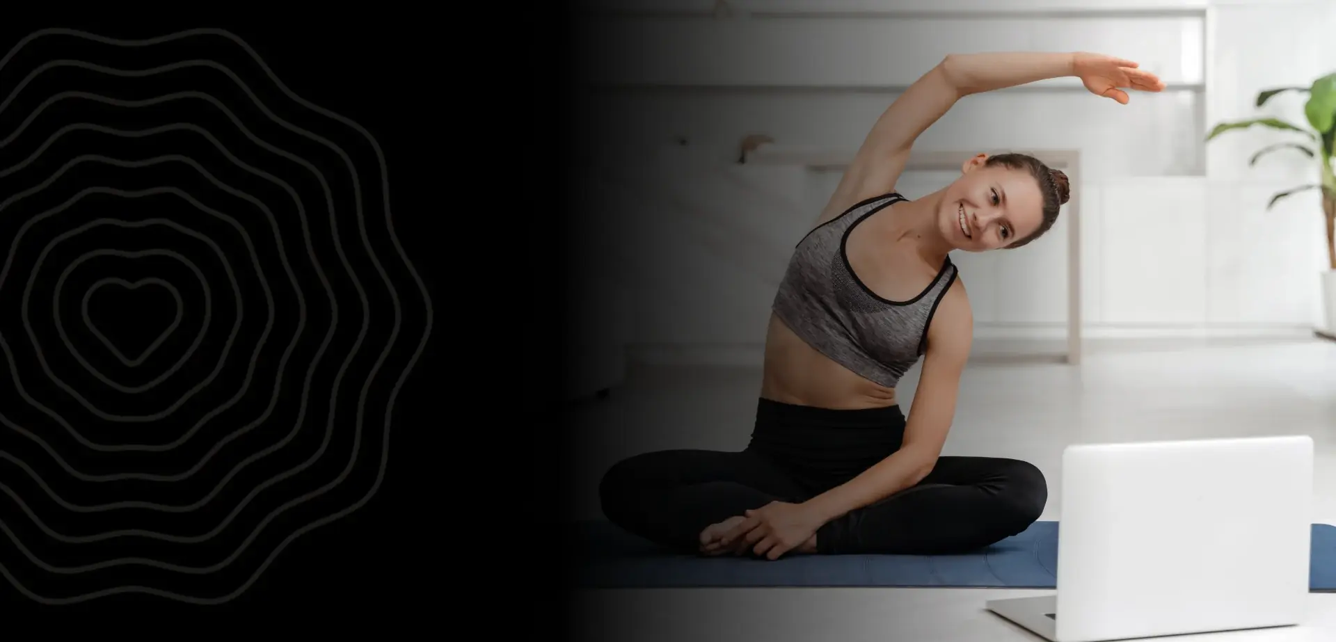 A woman in a seated side stretch during an online yoga session at home